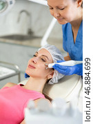 Adult woman cosmetologist doing microcurrent procedure to young woman. Стоковое фото, фотограф Яков Филимонов / Фотобанк Лори