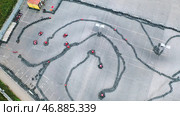 Aerial view of the karts pilots traning or competing on the karting trace in protective uniform and helmet. Стоковое фото, фотограф David Kashakhi / Фотобанк Лори