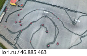 Racers traning or competing on the karting track in protective uniform and helmet, aerial view. Стоковое фото, фотограф David Kashakhi / Фотобанк Лори