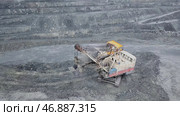 Excavator falls asleep rubble in dumper on outdoor quarry in extraction of minerals. Стоковое фото, фотограф David Kashakhi / Фотобанк Лори