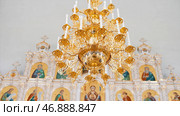 Chandelier with artificial candles in the temple with iconostasis. Стоковое фото, фотограф David Kashakhi / Фотобанк Лори