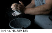 male powerlifter hand in talc and sports wristbands preparing to bench press. Стоковое фото, фотограф David Kashakhi / Фотобанк Лори