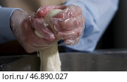 Close up for hands of a cheesemaker cutting mozzarella with hands, traditional food concept. Стоковое фото, фотограф David Kashakhi / Фотобанк Лори