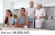 Elderly parents make claims to young couple in home kitchen. Стоковое видео, видеограф Яков Филимонов / Фотобанк Лори