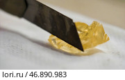 Extreme close up for yellow transparent mineral stone touched by cutter on white fabric background. Стоковое фото, фотограф David Kashakhi / Фотобанк Лори