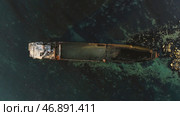 Aerial top view for wrecked ship along the rocky coast in blue water. Стоковое фото, фотограф David Kashakhi / Фотобанк Лори