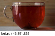 Red hibiscus tea on wooden wall background, concept of an alternative way to treat and prevent flu and colds. Стоковое фото, фотограф David Kashakhi / Фотобанк Лори