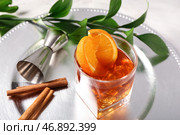 Металлическая тарелка с бокалом вкусного коктейля "Олд-фэшнед", апельсиновыми ломтиками и палочками корицы на белом фоне. Стоковое фото, фотограф Pixel_shot / Фотобанк Лори