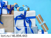 Стопка различных подарков для празднования Хануки и крутящиеся дрейдели на цветном фоне, крупным планом. Стоковое фото, фотограф Pixel_shot / Фотобанк Лори