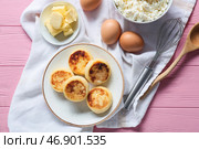 Тарелка с вкусными сырниками и ингредиентами на розовом деревянном фоне. Стоковое фото, фотограф Pixel_shot / Фотобанк Лори