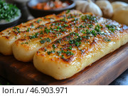 A mouthwatering dish of fried potato sticks with a crispy golden crust, generously sprinkled with fresh herbs. The surface of the treat is covered with a shiny glaze of butter, giving additional juiciness and flavor. The dish is served on a wooden board, and in the background you can see garlic, potatoes and spices, which enhances the atmosphere of home cooking. The light is soft and natural, emphasizing the texture and rich colors of the dish. Стоковое AI-изображение, AI-художник Анна Кривицкая / Фотобанк Лори