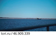 Huge ships with cargo move through the snowy sea, behind which the forest is visible. Стоковое фото, фотограф David Kashakhi / Фотобанк Лори