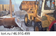 In the snow, a bulldozer spins its wheels when it pulls something heavy. Стоковое фото, фотограф David Kashakhi / Фотобанк Лори