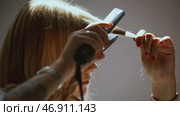 The girl winds curls on a curling iron. Стоковое фото, фотограф David Kashakhi / Фотобанк Лори