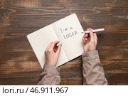 Женщина пишет текст Я НЕУДАЧНИЦА в блокноте на деревянном фоне. Стоковое фото, фотограф Pixel_shot / Фотобанк Лори