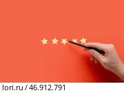 Мужская рука и звезды рейтинга на красном фоне. Концепция опроса. Стоковое фото, фотограф Pixel_shot / Фотобанк Лори