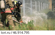 Two masked men who conduct exercises with a hose and water with special equipment and in a special uniform. Стоковое фото, фотограф David Kashakhi / Фотобанк Лори
