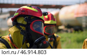 Two masked men who conduct exercises with a hose and water with special equipment and in a special uniform. Стоковое фото, фотограф David Kashakhi / Фотобанк Лори