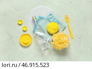 Скомканная пластиковая бутылка с различными крышками, губками, микрофиброй и вилкой на зеленом потертом фоне. Стоковое фото, фотограф Pixel_shot / Фотобанк Лори