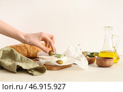 Женская рука с вкусным сыром фета, оливками и розмарином на белом фоне. Стоковое фото, фотограф Pixel_shot / Фотобанк Лори