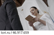 Action.Beautiful newlyweds with a bright spectacular bride in a white dress and a groom in a suit who take vows at their wedding. Стоковое фото, фотограф David Kashakhi / Фотобанк Лори