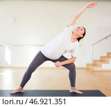 Pregnant woman is engaged in yoga. Extended Side Angle Pose or Utthita Parsvakonasana. Стоковое фото, фотограф Татьяна Яцевич / Фотобанк Лори