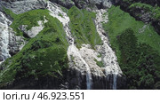 Waterfall flowing down from high mountains on a Sunny day. Стоковое фото, фотограф David Kashakhi / Фотобанк Лори