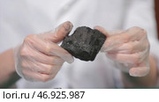 Male hands in gloves holding coal. Стоковое фото, фотограф David Kashakhi / Фотобанк Лори