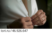 Close up of man dressing up and adjusting white shirt with cufflinks. Стоковое фото, фотограф David Kashakhi / Фотобанк Лори