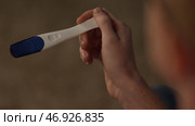 Positive pregnancy test held by a surprised man. Стоковое фото, фотограф David Kashakhi / Фотобанк Лори