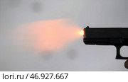 Close profile of man holding a 9 mm handgun, then takes a shot. Стоковое фото, фотограф David Kashakhi / Фотобанк Лори
