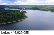 A huge bridge over a large river against the background of a cloudless sky and huge forest trees. Стоковое фото, фотограф David Kashakhi / Фотобанк Лори