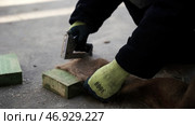 A man makes a special fiber for insulation of floors in houses with a stapler. Стоковое фото, фотограф David Kashakhi / Фотобанк Лори
