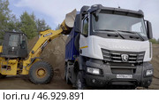 Excavation work is being carried out on a construction site using an excavator for dumping earth loading into truck (2022 год). Редакционное фото, фотограф David Kashakhi / Фотобанк Лори
