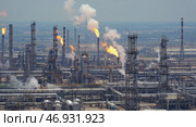Промышленный комплекс нефтеперерабатывающих заводов с факельными трубами, извергающими пламя и дым, на контрастном снимке с воздуха. Стоковое AI-изображение, AI-художник ФотоИнтеллект / Фотобанк Лори