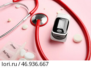 Пульсоксиметр со стетоскопом и таблетками на цветном фоне, крупным планом. Стоковое фото, фотограф Pixel_shot / Фотобанк Лори