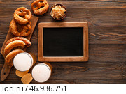 Стаканы холодного пива, пустая доска, доска с баварскими сосисками и закусками на деревянном фоне. Празднование Октоберфеста. Стоковое фото, фотограф Pixel_shot / Фотобанк Лори