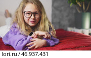 Young schoolgirl using smart watch for learning, tracking tasks, and exploring interactive functions. Concept of children adapting to technology, early tech education, and smart digital experiences. Стоковое видео, видеограф Енваев Андрей / Фотобанк Лори
