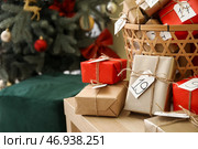 Адвент-календарь с подарочными коробками в корзине на столе возле елки, крупным планом. Стоковое фото, фотограф Pixel_shot / Фотобанк Лори