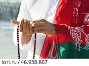 Мусульманин с флагом Афганистана и тасбихом на городской улице, крупным планом. Стоковое фото, фотограф Pixel_shot / Фотобанк Лори