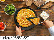 Женщина берет кусок пирога со шпинатом на деревянном фоне. Стоковое фото, фотограф Pixel_shot / Фотобанк Лори