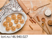 Форма для выпечки с сырыми булочками с корицей на деревянном фоне. Стоковое фото, фотограф Pixel_shot / Фотобанк Лори