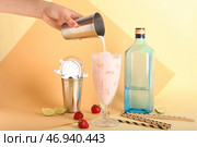 Женщина наливает клубничный коктейль Пина Колада в стакан на цветном фоне. Стоковое фото, фотограф Pixel_shot / Фотобанк Лори