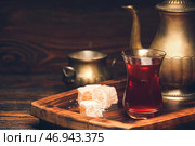 Стакан вкусного турецкого чая, лакомства и чайник на деревянном фоне. Стоковое фото, фотограф Pixel_shot / Фотобанк Лори