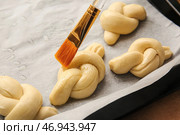 Смазывать сырые чесночные булочки маслом на цветном фоне, крупным планом. Стоковое фото, фотограф Pixel_shot / Фотобанк Лори