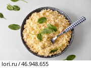 Чаша с вкусным кус-кусом и шпинатом на светлом фоне. Стоковое фото, фотограф Pixel_shot / Фотобанк Лори