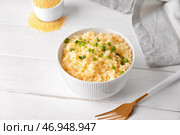 Чаша с вкусным кус-кусом и зеленым луком на светлом деревянном фоне. Стоковое фото, фотограф Pixel_shot / Фотобанк Лори