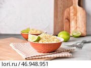 Чаши с вкусным кус-кусом и лаймом на столе. Стоковое фото, фотограф Pixel_shot / Фотобанк Лори