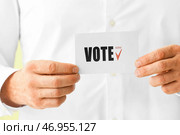 Мужчина держит бумагу с текстом VOTE, крупным планом. Стоковое фото, фотограф Pixel_shot / Фотобанк Лори