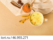 Чашка полезного латте из куркумы с порошком, звездчатым анисом и корицей на цветном фоне. Стоковое фото, фотограф Pixel_shot / Фотобанк Лори